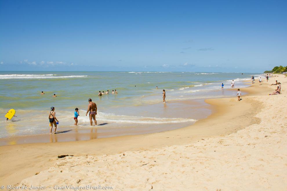 Imagem de pessoas nas águas calmas da Praia de Apaga Fogo em Arraial D`Ajuda.
